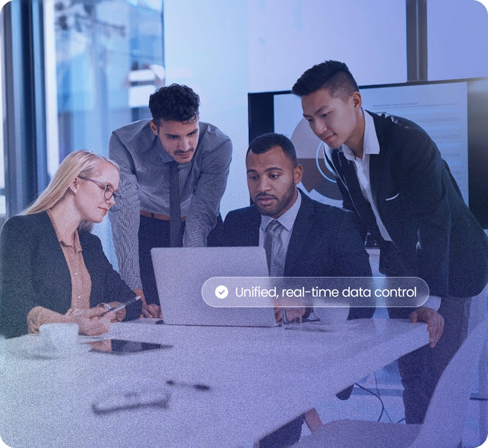 Team collaborating around a laptop — unified, real-time data control
